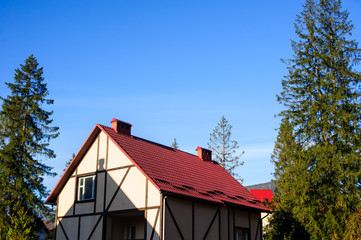 red metal tiles roof over the blue sky