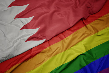 waving colorful gay rainbow flag and national flag of bahrain.