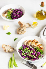 Grilled chicken, red cabbage, green peas and beans on light background. Delicious balanced food concept. Healthy lunch or dinner salad.