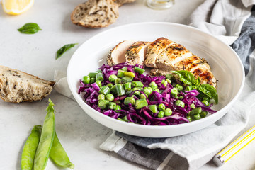 Grilled chicken, red cabbage, green peas and beans on light background. Delicious balanced food concept. Healthy lunch or dinner salad.