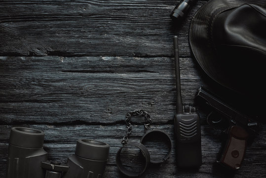 Detective or spy agent wooden black table flat lay background with copy space. Secret service agent work table.