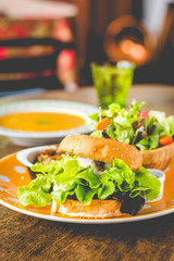 Home-made tofu burger carefully made of tofu and onion teriyaki sauce.small pan fried shredded potato and small salad and pumpkin soup