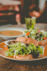 Home-made tofu burger carefully made of tofu and onion teriyaki sauce.small pan fried shredded potato and small salad and pumpkin soup