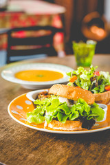 Home-made tofu burger carefully made of tofu and onion teriyaki sauce.small pan fried shredded potato and small salad and pumpkin soup