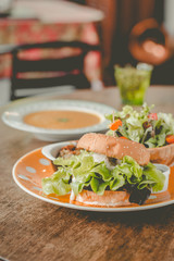 Home-made tofu burger carefully made of tofu and onion teriyaki sauce.small pan fried shredded potato and small salad and pumpkin soup