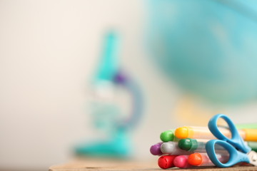 Concert education globe books microscope and pencils on background.