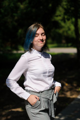 teenage girl in white blouse in green summer park