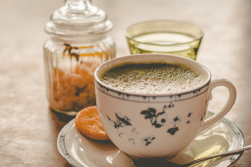 green tea matcha soy latte in a china cup with brown sugar and a glass of water on the side