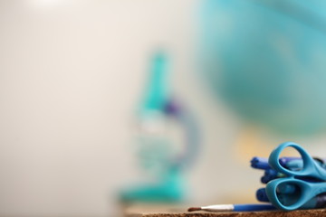 Concert education globe books microscope and pencils on background.