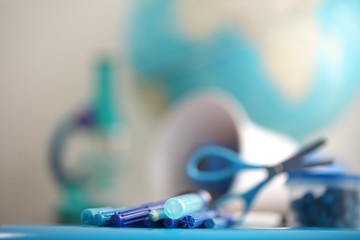 Concert education globe books microscope and pencils on background.