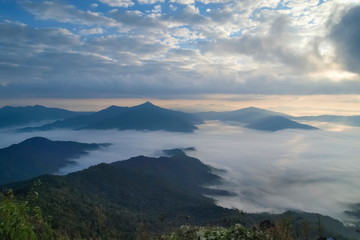 Mountain view morning of top hill around with sea of mist in valley with cloudy sky background, sunrise at Pha Tang, Chiang Rai, northern of Thailand.