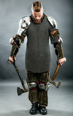 Medieval warrior berserk Viking with axes.