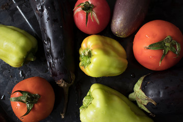 Fresh vegetables on black background, healthy food concept, diet, slimming. Tomatoes, eggplant,...