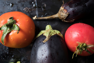 Fresh vegetables on black background, healthy food concept, diet, slimming. Tomatoes, eggplant,...
