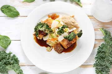 food dish. Vegetable cutlet stuffed with spinach, sun-dried tomatoes, marinated turnip, kimchi salad, bean puree, kale chips and mushroom tapioca