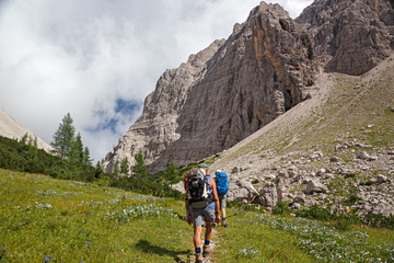 Some hikers walk along a mountain path.