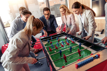 Coworkers playing table football