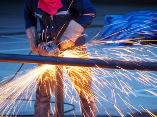 Worker grinds the Steel of angular grinding machine
