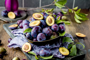 close-up view of fresh organic juicy plums in bowl on table 