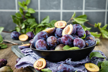 close-up view of fresh organic juicy plums in bowl on table 