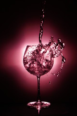 Pouring water into glass , black background and red light