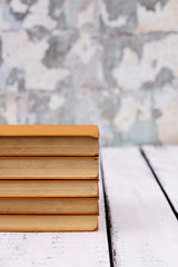Stack of old ancient shabby books on a white wooden background.