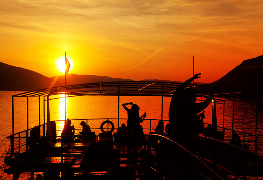 People Are Dancing On The Deck Of A Ship In The Twilight