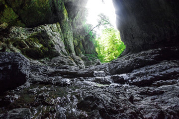 Mountain river creeck flowing in dark cave