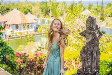 Young woman in dress in Water Palace Soekasada Taman Ujung Ruins on Bali Island in Indonesia. Amazing old architecture. Travel and holidays background