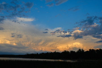 dramatic sunlit storm clouds over lake