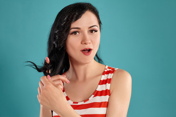Close-up shot of a beautiful girl posing against a blue background.