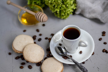 poured aromatic coffee into a white cup and saucer, laid coffee beans next to me, and dotted the background with flowers. Appetizingly look pastries bisé.