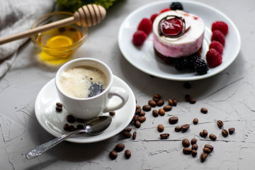 poured aromatic coffee into a white cup and saucer, laid coffee beans next to me, and dotted the background with flowers. Appetizingly look pastries bisé.