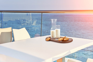 Table for two served with a breakfast on outdoor hotel balcony with a sea view.