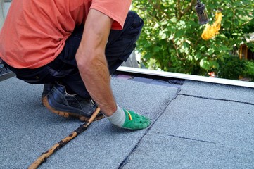 Flat roof installation with propane blowtorch during construction works with roofing felt. Heating...