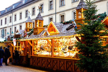Fototapeta premium Traditional christmas market in the historic center of Nuremberg, Germany. Decorated with garland and lights sale stalls with sweets, mulled wine and Xmas decoration and German gifts.
