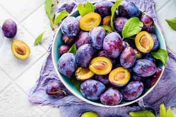 close-up view of fresh organic juicy plums in bowl on table 
