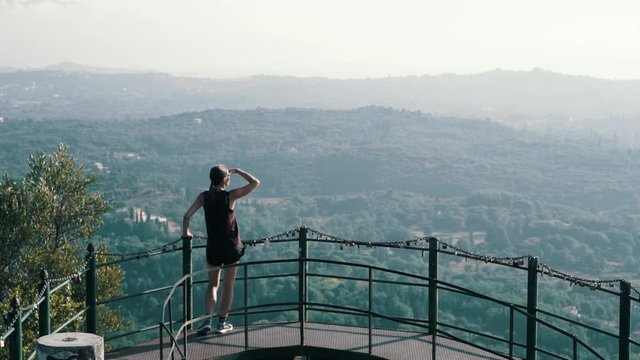 Hiker Woman enjoy the view Standing On Observation Deck Over City Creece Korfu