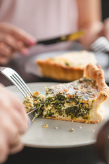 the process of eating girls in a cafe. Close up Photo of female hands holding fork and knife cutting a piece of salty pie
