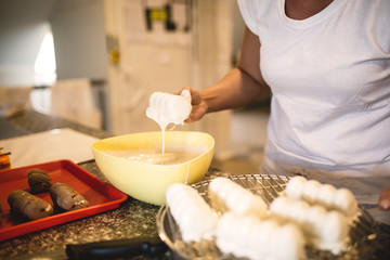 A woman decorates and makes cakes in a pastry shop