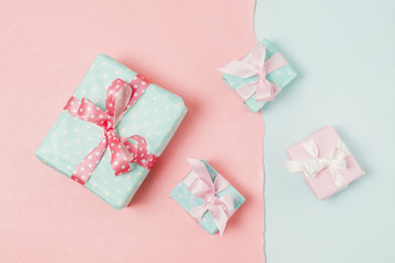 Small and big decorated gift boxed tied with ribbon arrange on peach and blue wallpaper