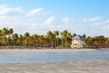 Beautiful Crandon Park Beach located in Key Biscayne in Miami, Florida, USA. Palms, white sand and security house