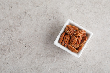 White square bowl of pecan nuts. Healthy eating concept