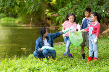 Group family asian children collecting garbage and plastic on the river to dumped into the trash for volunteer charity save environment.  Ecology earth Concept.