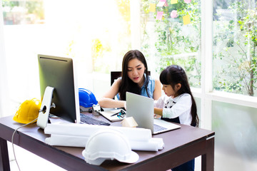 Businesswoman mother woman with daughter working at the computer. Mother working at home concept