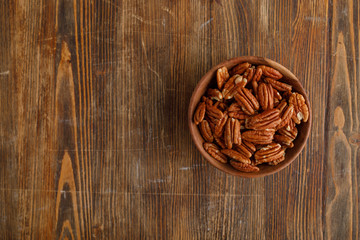 Wooden bowl of pecan nuts. Healthy eating concept