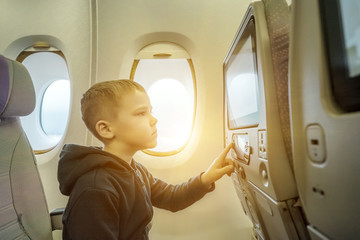 Adorable little boy traveling by airplane. Child sitting by airc