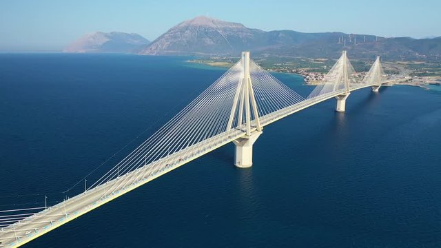 Aerial drone video of world famous cable suspension bridge of Rio - Antirio Harilaos Trikoupis, crossing Corinthian Gulf, mainland Greece to Peloponnese, Patras