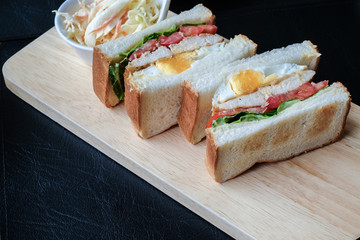 Freshly made club sandwiches served on a wooden chopping board