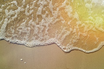 Soft focus of the waves beat at the beach with shell fragments with sunlight in summer time. Nature background concept.